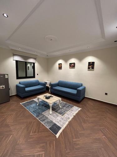 a living room with two blue couches and a table at غرفة وصالة بنظام فندقي مميز in Jeddah
