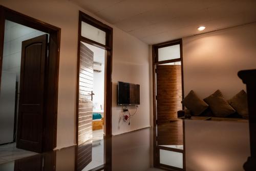 a room with a door with a television and a mirror at Station House in Dahab