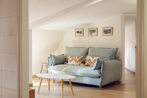 a blue couch in a living room with a table at Chelsea Cedeira VIVIENDAS USO TURISTICO in Cedeira