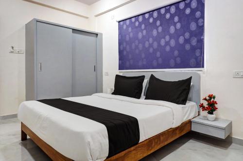 - une chambre avec un grand lit et un mur pourpre dans l'établissement Super Hotel O Esta Inn, à Pune