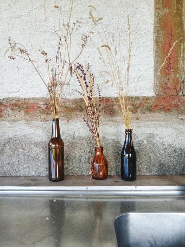 three vases sitting on a shelf next to a wall at Gula Vagnen på en äng i lantlig miljö in Hörby