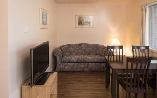 a living room with a couch and a table at Beachside Motel in Penticton