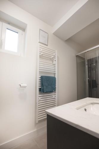 une salle de bain blanche avec un lavabo et un miroir dans l'établissement Résidence Cawikima - Carla House, à Boulogne-sur-Mer