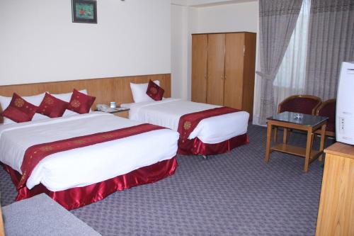 a hotel room with two beds and a television at Quality Inn Dhaka in Dhaka