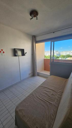 une chambre avec un lit et une télévision dans une pièce dans l'établissement Studio - 2min Mer & Plages - Grau du Roi, au Grau-du-Roi
