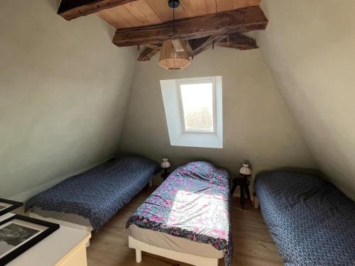 deux lits dans une chambre avec une fenêtre dans l'établissement Piscine, Charme et Calme au coeur du Périgord, à Finsac