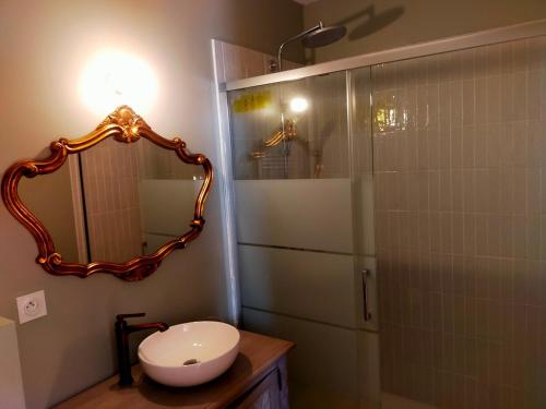 une salle de bain avec un lavabo et un miroir dans l'établissement Piscine, Charme et Calme au coeur du Périgord, à Finsac