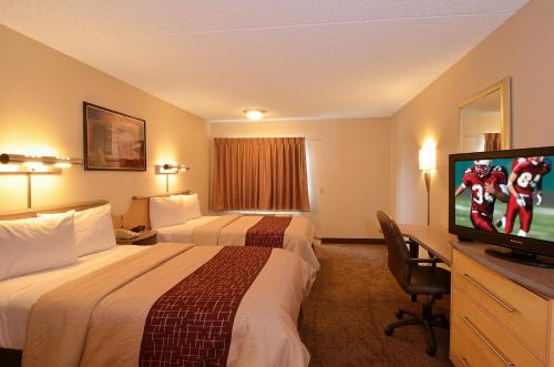 a hotel room with two beds and a flat screen tv at Red Roof Inn San Antonio Airport in San Antonio