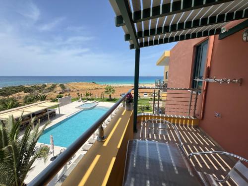 a balcony of a house with a swimming pool and the ocean at Pachia Ammos Falasarna in Falasarna