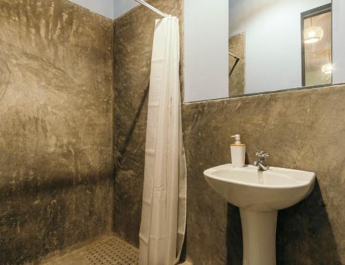a bathroom with a sink and a toilet and a mirror at Spondylus Home in Máncora