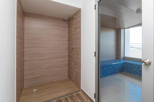 a bathroom with a shower with a tub at Clubh310 Apartamento con piscina, gimnasio y barbacoa, vistas a la coordillera in Armenia