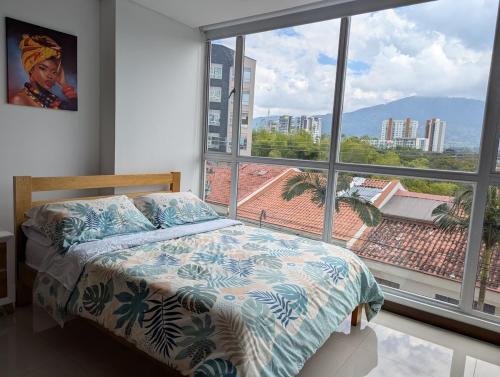a bedroom with a bed and a large window at Clubh310 Apartamento con piscina, gimnasio y barbacoa, vistas a la coordillera in Armenia
