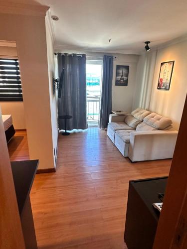 a living room with a bed and a couch at Barra da Tijuca - 508 - De Frente para Maravilhosa Piscina - Estacionamento Gratuito - Academia Comphania Atletica - Balsa para Praia Grátis - Microondas - Geladeira Grande - Recepção 24horas - Wi-Fi - Com Pia in Barra da Tijuca