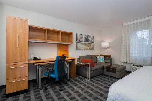 a hotel room with a desk and a bed and a couch at TownePlace Suites by Marriott Boise Downtown/University in Boise