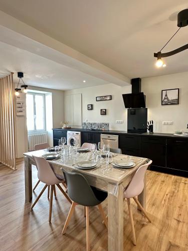 une salle à manger avec une table et des chaises ainsi qu'une cuisine dans l'établissement Le Repos urbain, près de Carat et Naval group, à Ruelle-sur-Touvre