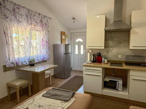 a kitchen with a stainless steel refrigerator and a table at Apartman Meghan in Pula