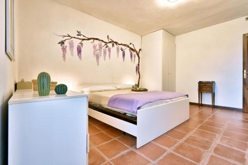 a bedroom with a bed with a branch on the wall at Antica Limonaia by Theater Home in Muslone