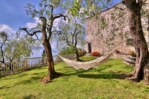 a hammock hanging between two trees in a yard at Antica Limonaia by Theater Home in Muslone