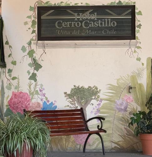 a sign on a wall with a bench and plants at Hotel Cerro Castillo in Viña del Mar