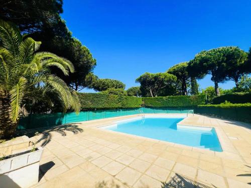 une piscine dans un jardin arboré dans l'établissement Villegiales Tee1 - 2 pièces cabine en rez de jardin avec piscine clim MAE-6313, à La Grande Motte