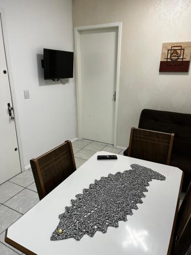 a white table with a black item on top of it at AP 100m do mar mesma rua do Quiosque VavaZão in Capão da Canoa