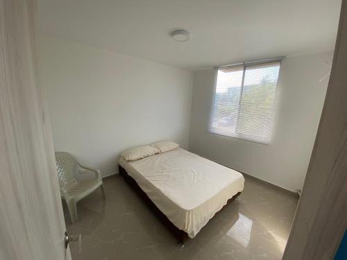 a small bedroom with a bed and a window at Apartamento Ricaurte Cund in Girardot