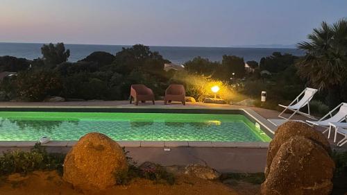 une piscine avec des chaises et une vue sur l'océan dans l'établissement Villa 8 personnes entre l'ile rousse et Calvi avec piscine., à Lumio