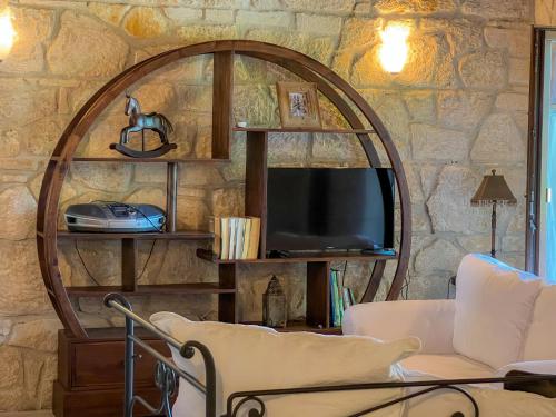 a living room with a stone wall at Villa Posidi with Private Pool and Sea View in Possidi