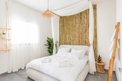 a bedroom with a white bed with towels on it at טל תאי בוטיק - Tal Thai Boutique in Shelomi