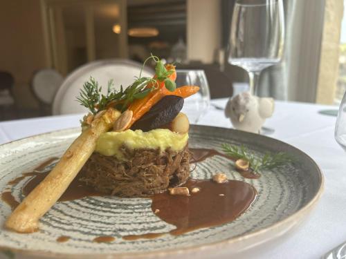 a plate of food with vegetables on a table at Le Victor Hugo - Hôtel et Restaurant - Logis Hôtels in Saint-Céré