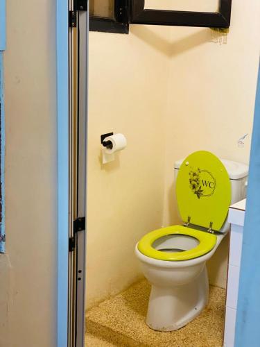a bathroom with a toilet with a yellow seat at Résidence NATANGUE 1 - Studio Coco Loco in Sali Nianiaral