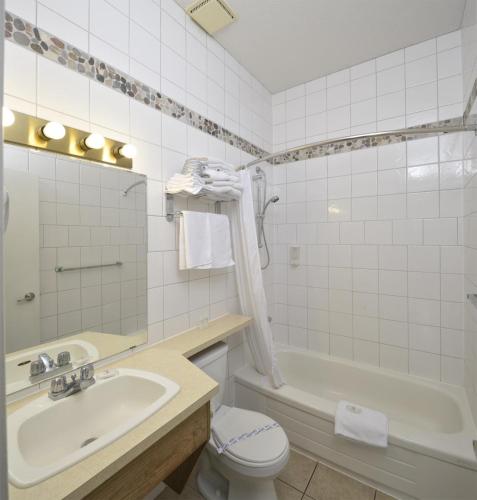 a bathroom with a sink and a tub and a toilet at Waterfront Inn in Penticton