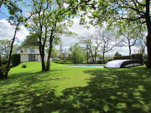 a mattress on a lawn in a yard with trees at Kerwall - Maison d'hôtes in Malville