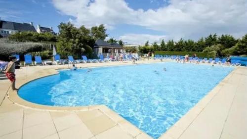 une grande piscine bleue avec des gens dedans dans l'établissement Le Petit Voyageur - Piscine - Plage - Balcon - 4pers, à Arzon