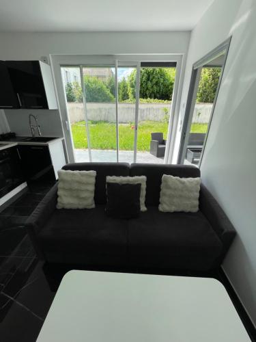 a black couch with two pillows in a living room at Loft design in Thiais