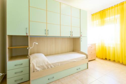 a bedroom with a bed with white cabinets and a window at Casa Rachele in Porto San Giorgio