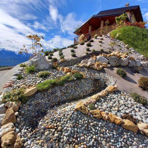a rock garden on a hill with a house at Agriturismo Hegemone in Tremosine Sul Garda