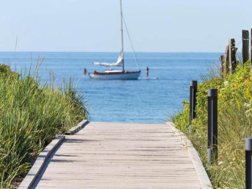 a boat on the water next to a wooden path at Wohnung mit großem Garten an der Ostseeküste in Neubukow