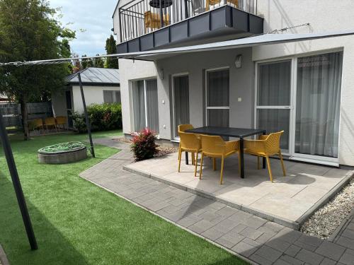 patio ze stołem i krzesłami na podwórku w obiekcie Silver Lelle Apartman Balatonlelle w mieście Balatonlelle