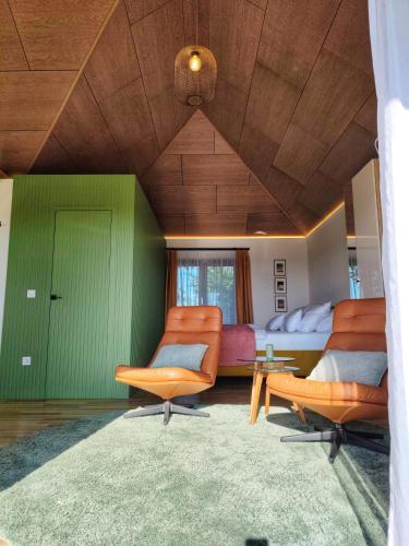a living room with green walls and orange chairs at VillaPince in Garabonc