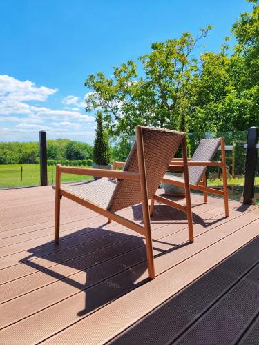 two wicker chairs sitting on top of a wooden deck at VillaPince in Garabonc