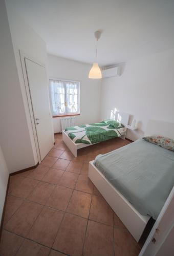 a bedroom with two beds and a window at Conero Cottage in Porto Recanati