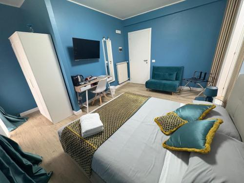 a bedroom with a large bed with blue walls at Casa flowers in Ciampino