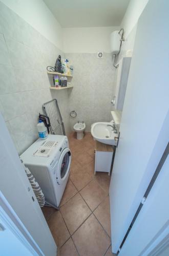 a bathroom with a washing machine and a sink at Conero Cottage in Porto Recanati