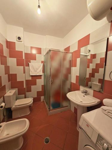 a bathroom with a shower and a toilet and a sink at Sion Sarande Apartments in Sarandë