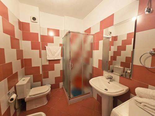 a bathroom with a shower and a toilet and a sink at Sion Sarande Apartments in Sarandë