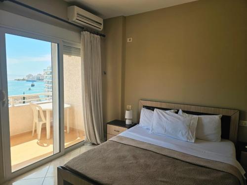 a bedroom with a bed and a view of the ocean at Sion Sarande Apartments in Sarandë