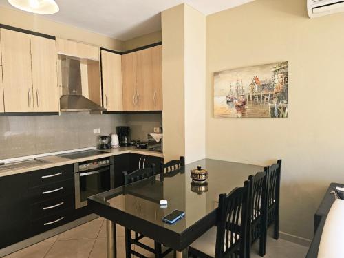 a kitchen with a table and chairs in a room at Sion Sarande Apartments in Sarandë