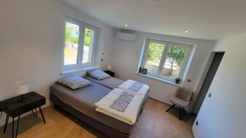 une chambre avec un lit et deux fenêtres dans l'établissement Gîte de la Chapelle-le houx, à Innenheim