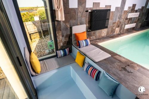 un banc installé à côté d'une piscine dans l'établissement Villa Ponant 5 étoiles à Doëlan, piscine face mer, à Clohars-Carnoët